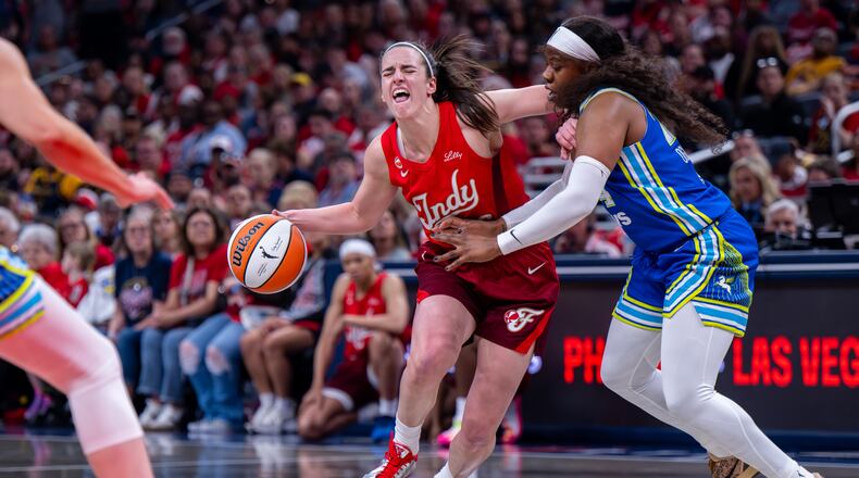Indiana Fever guard Caitlin Clark (22) reacts as she makes contact with the defense of Dallas Wings guard Arike Ogunbowale (24) during the first half of an WNBA basketball game in Indianapolis, Saturday, May 9, 2026. (AP Photo/Doug McSchooler)