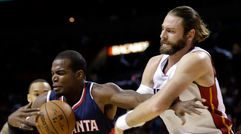 Atlanta Hawks forward Paul Millsap (4) is fouled by Miami Heat forward Josh McRoberts in the first half of an NBA basketball game, Wednesday, Dec. 3, 2014, in Miami. (AP Photo/Lynne Sladky)
