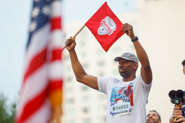 Atlanta Mayor Andre Dickens signals the start of the 57th running of the Peachtree Road Race at Lenox Square on Saturday. (Arvin Temkar/AJC)