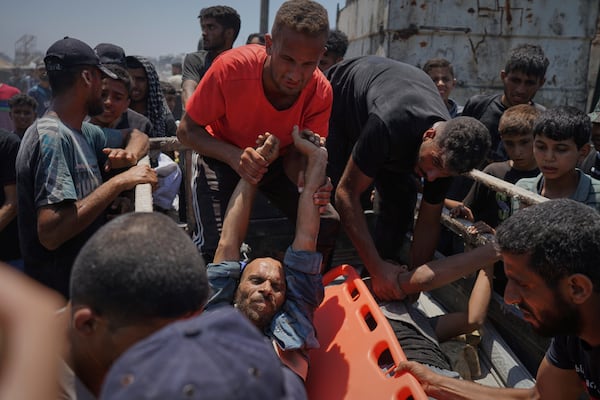 Injured Palestinians are transferred to an ambulance after being wounded while waiting for aid arriving from the northern Gaza Strip, in Gaza City, Tuesday, July 22, 2025. (AP Photo/Jehad Alshrafi)