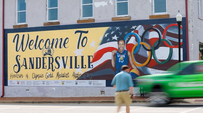 A pedestrian crosses North Harris Street in downtown Sandersville, where a mural is dedicated to Olympic gold medalist and Atlanta Dream player Allisha Gray on Tuesday, April 14, 2024. (Miguel Martinez / AJC)
