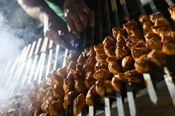 Sayaf Jbara, co-owner of Master Butcher, turns chicken skewers on the grill during the Atlanta Ramadan Food Festival in Norcross on Friday, Feb. 27, 2026. (Arvin Temkar/AJC)