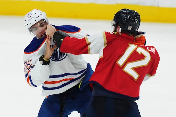 Edmonton Oilers' Darnell Nurse (25) and Florida Panthers' Jonah Gadjovich (12) fight during the third period in Game 3 of the NHL hockey Stanley Cup finals in Sunrise, Fla., Monday, June 9, 2025. (Nathan Denette/The Canadian Press via AP)