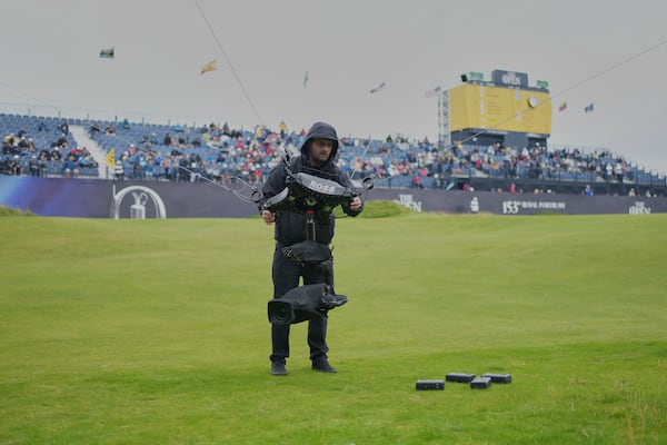 A technician changes the camera batteries on spidercam on the 18th green during the first round of the British Open golf championship at the Royal Portrush Golf Club, Northern Ireland, Thursday, July 17, 2025. (AP Photo/Jon Super)