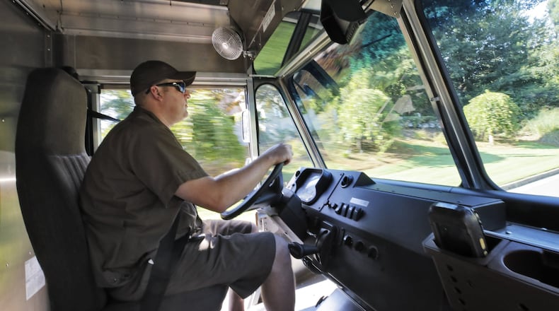 UPS driver Dan Partyka heads out on his route. It costs more to deliver items to individual doorsteps, so the rise of online shopping has forced UPS to adjust. BOB ANDRES /BANDRES@AJC.COM