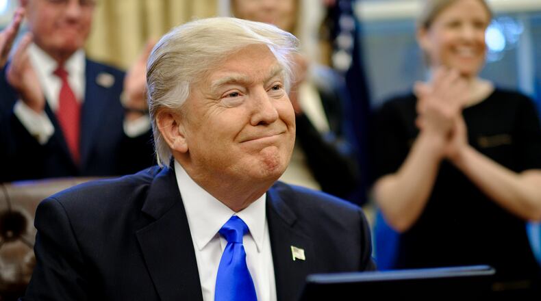 WASHINGTON, DC - JANUARY 28: President Donald Trump signs three executive actions in the Oval Office on January 28, 2017 in Washington, DC. The actions outline a reorganization of the National Security Council, implement a five year lobbying ban on administration officials and a lifetime ban on administration officials lobbying for a foreign country and calls on military leaders to present a report to the president in 30 days that outlines a strategy for defeating ISIS. (Photo by Pete Marovich - Pool/Getty Images)