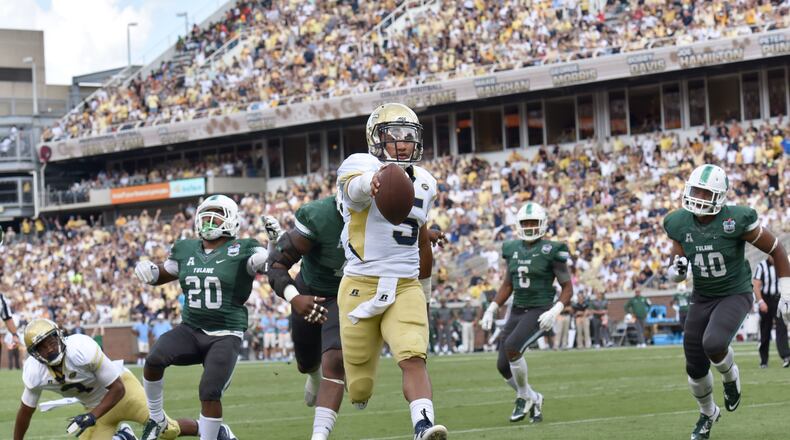 Georgia Tech Yellow Jackets quarterback Justin Thomas (5) holds a ball as he scores a touchdown against the Tulane Green Wave in the first half at Bobby Dodd Stadium on Saturday, September 12, 2015. HYOSUB SHIN / HSHIN@AJC.COM
