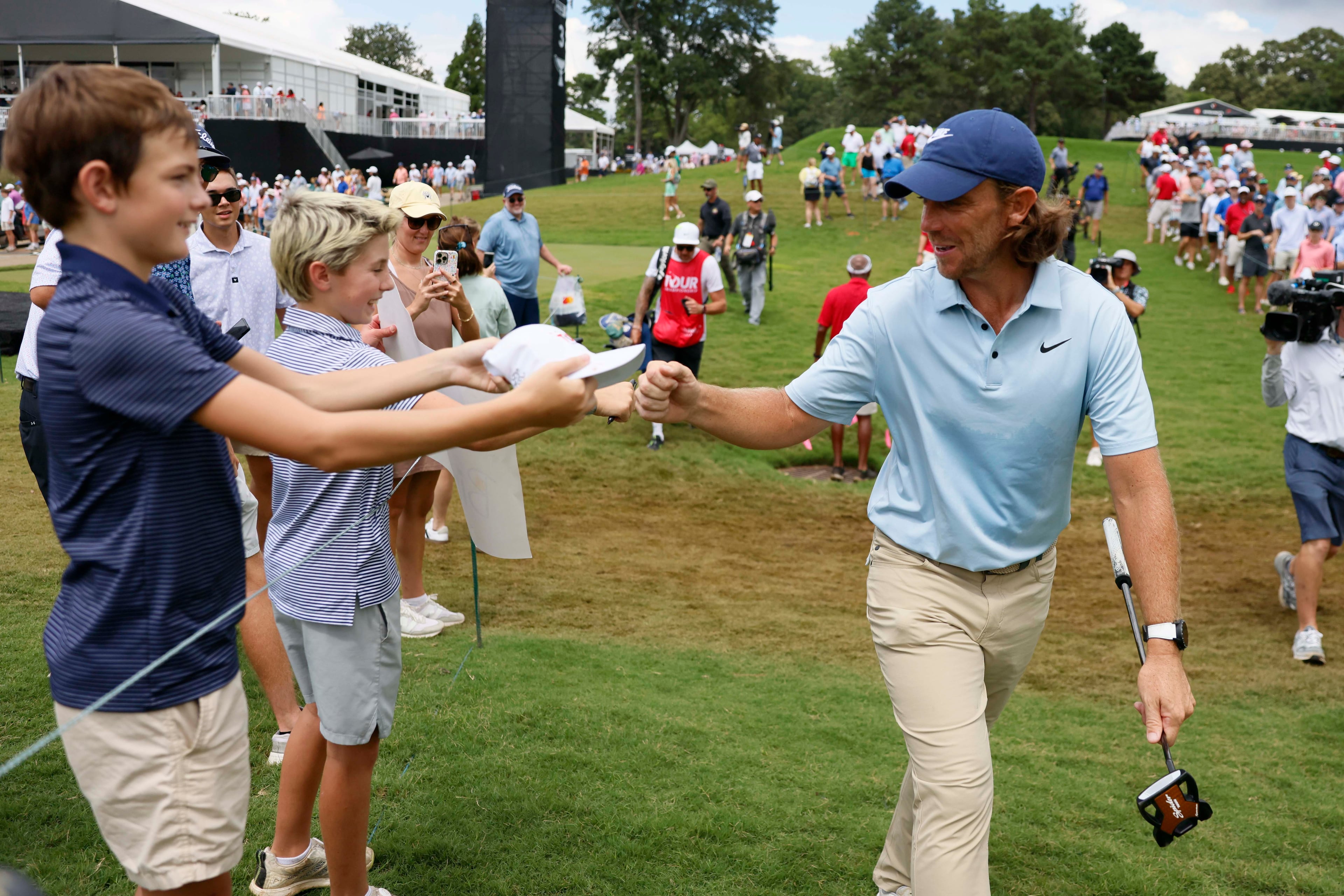 Tommy Fleetwood, of England, fist bump fans walking toward the fourth tee during the final round of the PGA Tour Championship at East Lake Golf Club, on Sunday, Aug. 24, 2025, in Atlanta. (Miguel Martinez/ AJC)