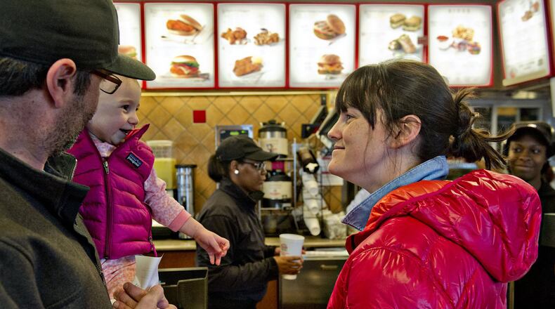 Colin McChesney holds his daughter, Evan, as he waits with wife Jessica for their order at a Chick-fil-A in East Point. A new FDA rule will require restaurants to list calories for their items, but Chick-fil-A has already started. Other restaurant operators and food sellers object to the rule.