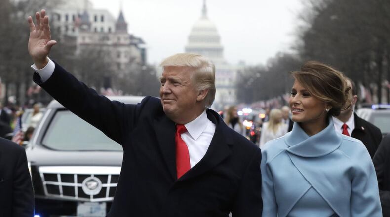 President Donald Trump waves as he walks with first lady Melania Trump during the inauguration parade on Pennsylvania Avenue in Washington. (AP Photo/Evan Vucci)