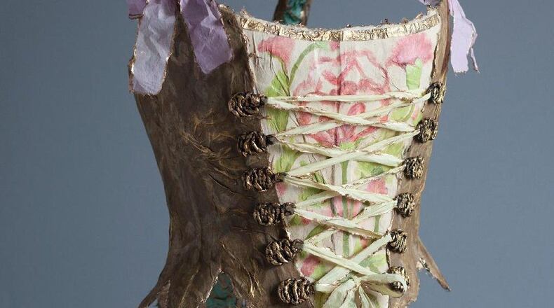 “Lady Plum Corset” in paper, 24K gold leaf, watercolor, Swarovski crystals and copper by Fabiola Jean-Louis appears at Alan Avery Art Company.