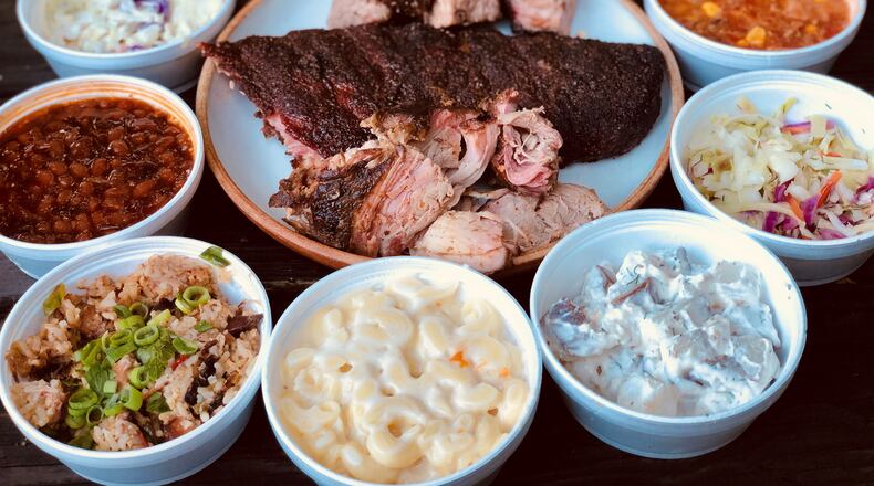 Takeout from Taylor’d Bar-B-Q includes brisket, ribs, pulled pork, plus all the fixings (clockwise from top): tots, Brunswick stew, vinegar slaw, potato salad, mac and cheese, Jambalaya Que, baked beans and creamy cole slaw. CONTRIBUTED BY WENDELL BROCK