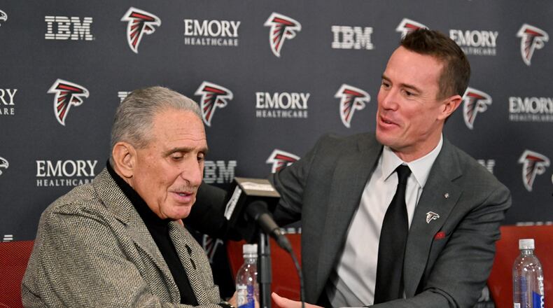 Matt Ryan holds a hand of Atlanta Falcons owner Arthur M. Blank during a news conference to introduce Ryan as the new Falcons president of football, Tuesday, Jan. 13, 2026, in Flowery Branch. (Hyosub Shin/AJC)
