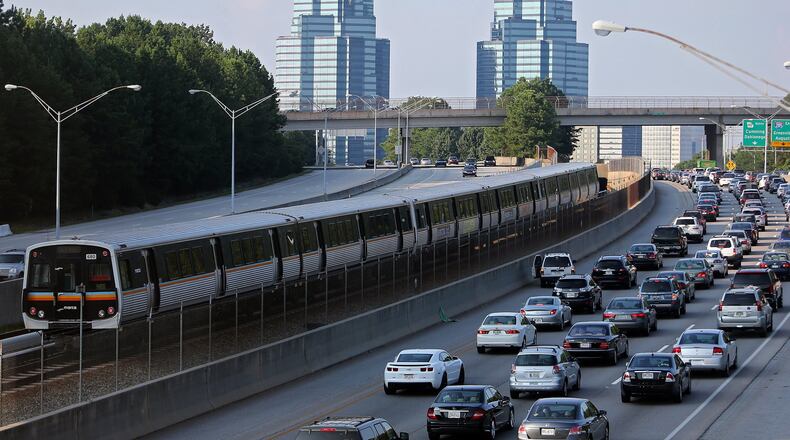 A MARTA train makes its way North past Ga. 400 traffic. Fulton County is seeking public input as it forms a transit plan. BEN GRAY / AJC FILE PHOTO