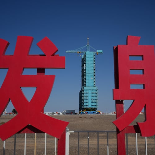 The Shenzhou-21 spacecraft sitting atop a Long March rocket covered on a launch pad is seen near the Chinese characters for launch, at the Jiuquan Satellite Launch Center in northwest China, Thursday, Oct. 30, 2025. (AP Photo/Andy Wong)