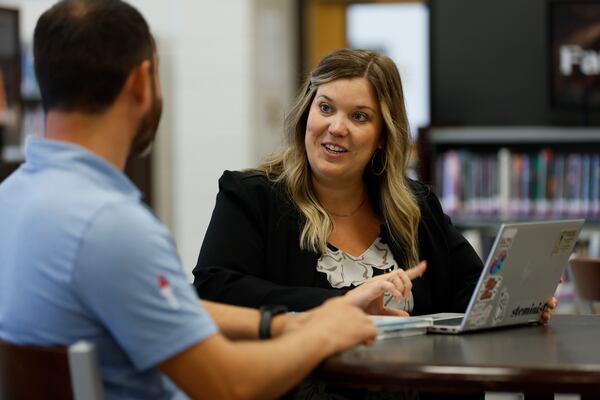 Sallie Holloway leads AI initiatives for Gwinnett County speaks with Tyler Kinney, a STEM education researcher at the Gwinnett School of Mathematics, Science, and Technology, prior to a training session. Several Georgia schools are preparing for the new school year, with some assistance from AI, as of Monday, July 21, 2025. (Miguel Martinez/AJC)