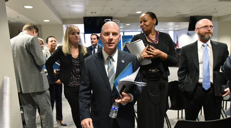 Frank W. Berry (center), Commissioner of Georgia Department of Community Health, leaves after a community health board meeting in August in Atlanta.
