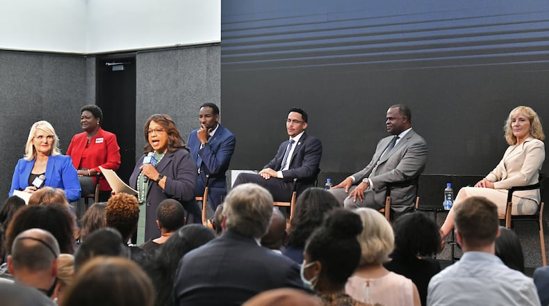 Mayoral candidates (background from left) Felicia Moore, Andre Dickens, Antonio Brown, Kasim Reed and Sharon Gay sit as hosts Lori Geary Talbert (left) and Condace Pressley speak during City of Atlanta Mayoral Debate at The Gathering Spot in Atlanta on Thursday, October 7, 2021. (Hyosub Shin / Hyosub.Shin@ajc.com)