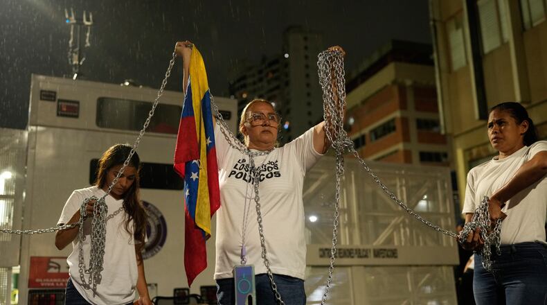 Relatives of people they consider to be detained for political reasons protest holding chains in front of police guarding the Zona 7 Bolivarian National Police detention center in Caracas, Venezuela, Friday, Jan. 30, 2026, on the same day acting President Delcy Rodríguez announced an amnesty bill that could lead to the release of hundreds of prisoners, including opposition leaders, journalists and human rights activists detained for political reasons. (AP Photo/Ariana Cubillos)