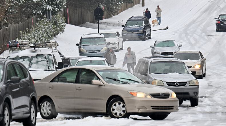 Vehicles get stuck in the snow on Old Snellville Highway on Friday, Jan. 10, 2025, in Lawrenceville. Georgia is bracing for a possibly significant winter storm expected this weekend. (Hyosub Shin/AJC)
