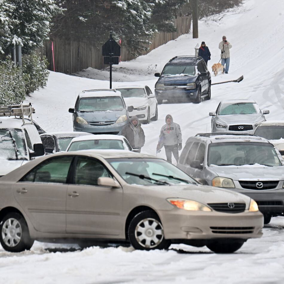 Vehicles get stuck in the snow on Old Snellville Highway on Friday, Jan. 10, 2025, in Lawrenceville. Georgia is bracing for a possibly significant winter storm expected this weekend. (Hyosub Shin/AJC)