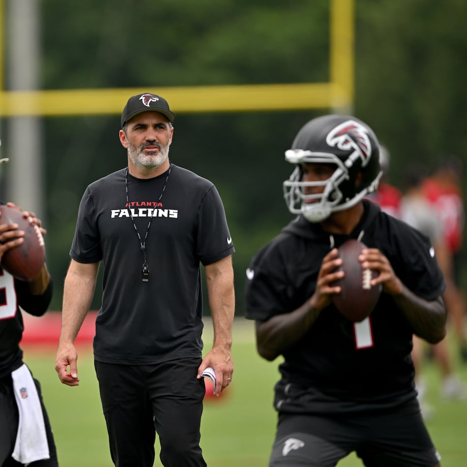 Atlanta Falcons head coach Raheem Morris watches as quarterback Michael Penix Jr. (left) and quarterback Tua Tagovailoa (right) run drills during an OTA workout at Atlanta Falcons Training Facility on Wednesday, May 27, 2026, in Flowery Branch. (Hyosub Shin/AJC)