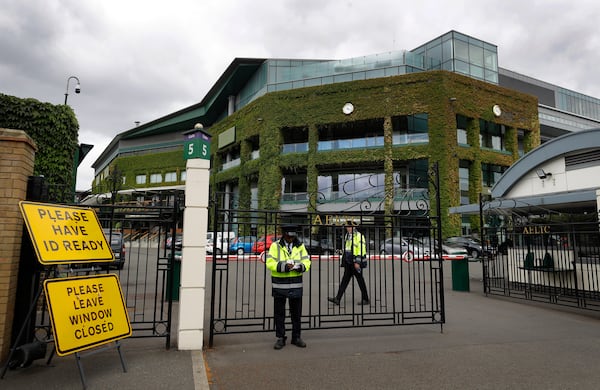FILE - Security guards at the entrance in front of Centre Court at the All England Lawn Tennis Club in Wimbledon in London, Monday, June 29, 2020. (AP Photo/Kirsty Wigglesworth,File)