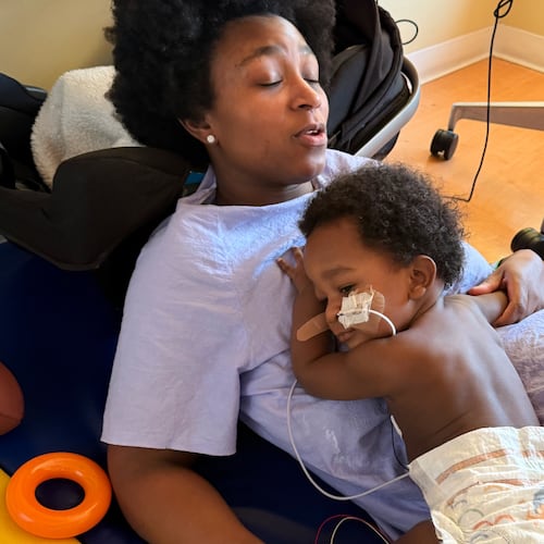 In this photo provided by the family, Ashaan Carter lies on his mother, Angel Carter, at a children's hospital in Portland, Ore., in November 2025, during his treatment for infant botulism after drinking ByHeart baby formula donated to vulnerable families, before a national recall of all of the products. (David Orphey via AP)