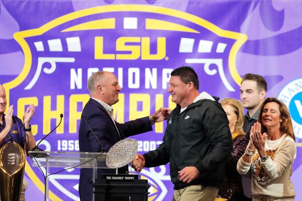 LSU head coach Ed Orgeron, right, is greeted by Louisiana Gov. John Bel Edwards during a celebration of their NCAA college football championship, Saturday, Jan. 18, 2020, on the LSU campus in Baton Rouge, La. (Gerald Herbert/AP)