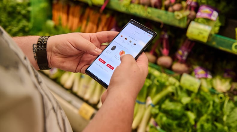 Josh Roberts, who uses Klarna, a buy-now, pay-later service, scrolls through Safeway’s app at one of the grocer’s stores near his home in Kenmore, Wash., July 19, 2022. Chona Kasinger/The New York Times