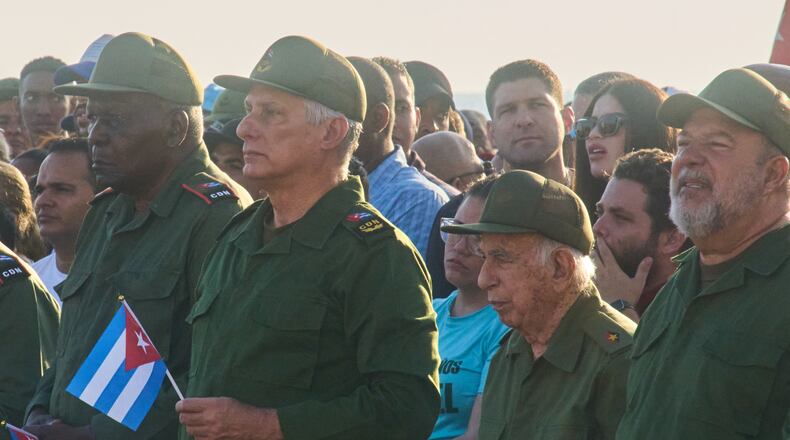 Cuba's President Miguel Diaz-Canel, second left, and Raul Castro's grandson Raul Guillermo Rodriguez Castro, center back, take part in a rally in support of former President Raul Castro in front of the U.S. Embassy in Havana, Cuba, Friday, May 22, 2026, after U.S. prosecutors filed an indictment accusing him of ordering the 1996 shootdown of civilian planes flown by Miami-based exiles. (AP Photo/Ramon Espinosa)