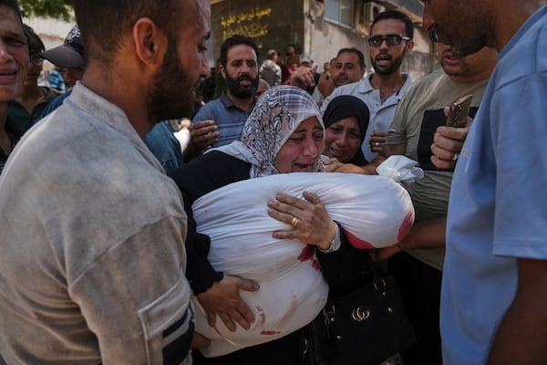 Palestinians mourn their relatives who were killed while trying to reach aid trucks entering northern Gaza through the Zikim crossing with Israel, at Shifa Hospital in Gaza City on Sunday, July 20, 2025. (AP Photo/Jehad Alshrafi)