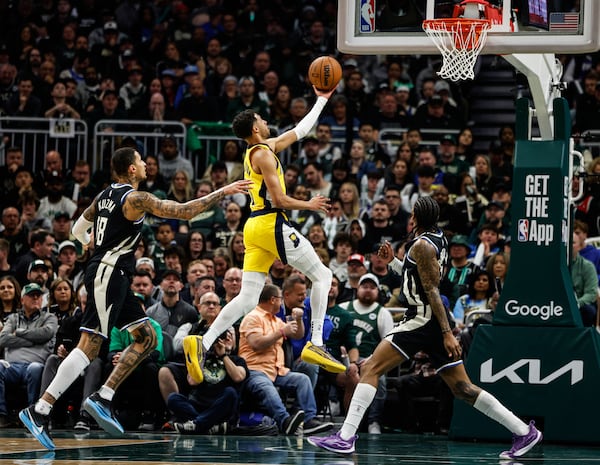 Indiana Pacers' Tyrese Haliburton, middle, puts up a shot against the Milwaukee Bucks during the first half of Game 4 of a first-round NBA basketball playoff series Sunday, April 27, 2025, in Milwaukee. (AP Photo/Jeffrey Phelps)