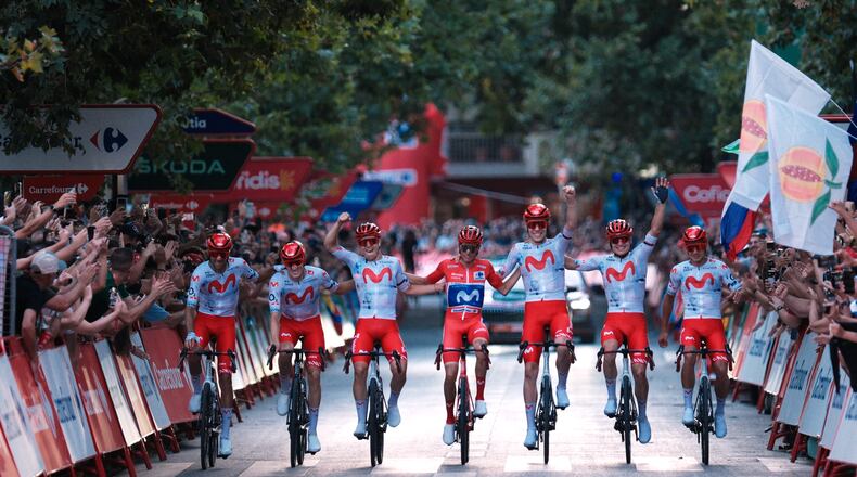 Spain's Enric Mas, center, flanked by his teammates, crosses the finish line during the 21st stage of the Spanish Vuelta cycling race, from Carrefour Granada to Granada, Spain, Sunday, Sept. 13, 2026. (AP Photo/Gregorio Marrero)