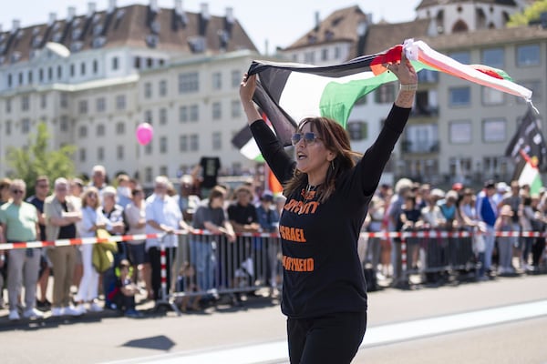 A protester raises a Palestinian flag, during the opening ceremony of the 69th Eurovision Song Contest, in Basel, Switzerland, Sunday, May 11, 2025. (Til Buergy/Keystone via AP)
