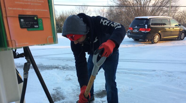 Harry Patel shovels snow at his BP station in Blue Ridge Saturday.