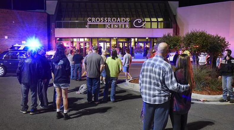People stand near the entrance on the north side of Crossroads Center mall between Macy's and Target as officials investigate a reported multiple stabbing incident, Saturday, Sept. 17, 2016, in St. Cloud, Minn. Police said multiple people were injured at the St. Cloud shopping mall on Saturday evening in an attack possibly involving both shooting and stabbing. The suspect is believed to be dead, St. Cloud Police Sgt. Jason Burke told the St. Cloud Times. (Dave Schwarz/St. Cloud Times via AP)