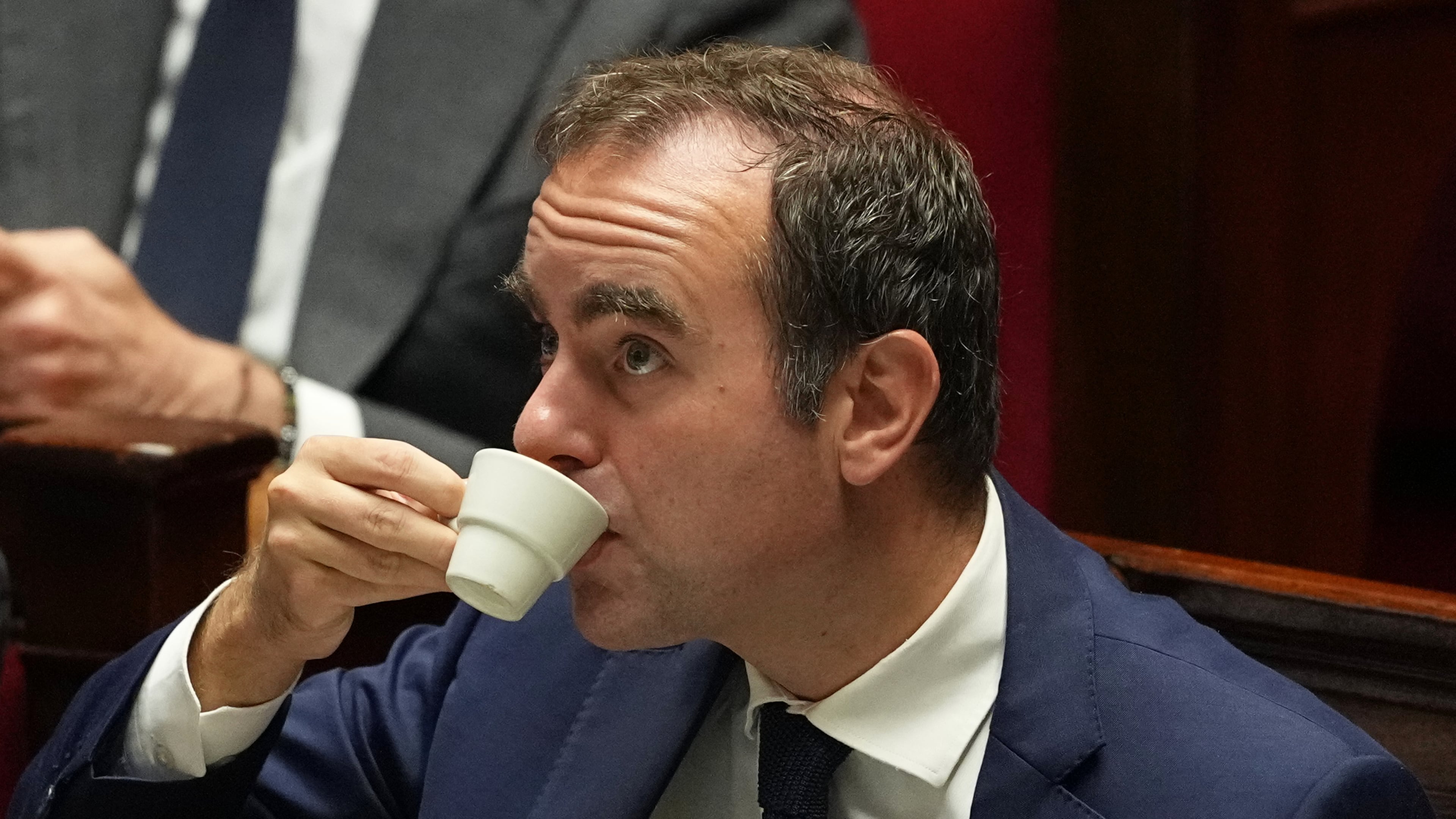 French Prime Minister Sebastien Lecornu drinks as he listens to speeches before a no-confidence vote, Thursday, Oct. 16, 2025 at the National Assembly in Paris. (AP Photo/Thibault Camus)
