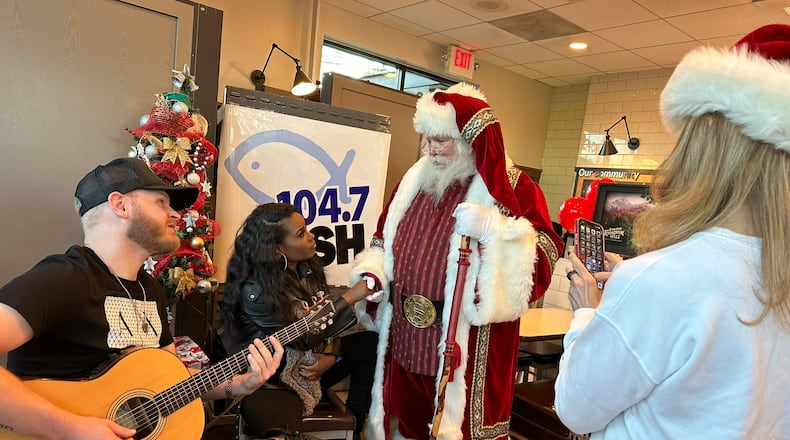 Crystal Nicole (second to left) performed at a Chick fil-A in Dunwoody for Fish 104.7's Christmas Wish program. Santa and afternoon host Beth Bacall are there, too. RODNEY HO/rho@ajc.com