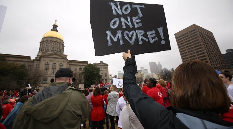 A protester holds a sign reading “Not one more” during rally that the gun control group Moms Demand Action Advocacy Day staged in 2018 at Liberty Plaza in Atlanta. Gun control advocates are hoping several pieces of legislation make it through the General Assembly this year, but they will likely meet resistance. PHOTO / JASON GETZ