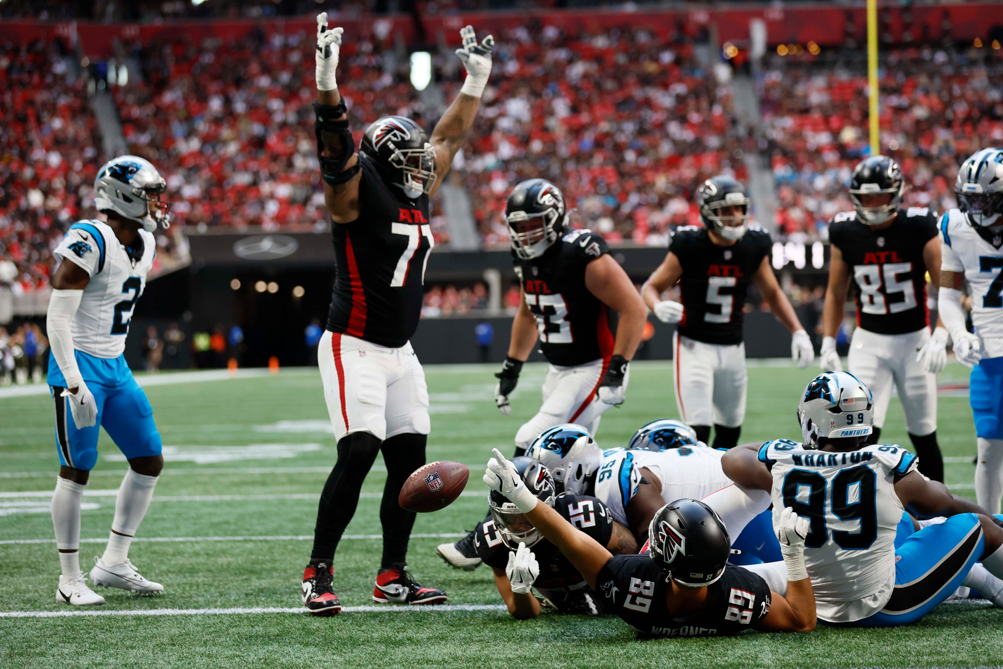 Atlanta Falcons offensive tackle Storm Norton (second from left) reacts as Atlanta Falcons running back Tyler Allgeier (bottom center) during the first half of an NFL football game against the Carolina Panthers at Mercedes-Benz Stadium in Atlanta on Sunday, Nov. 16, 2025. (Miguel Martinez/AJC)