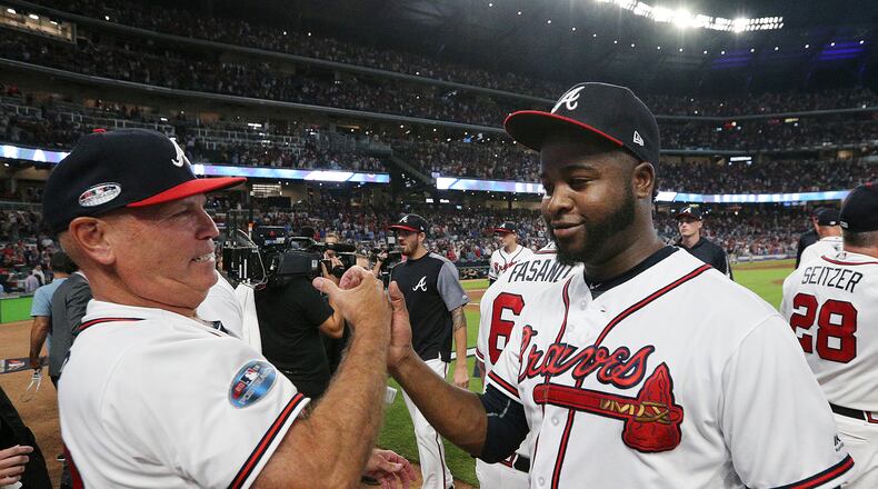 Braves manager Brian Snitker and closer Arodys Vizcaino share a little relief and happiness following the NLDS Game 3 victory over the Dodgers. (Curtis Compton/ccompton@ajc.com)