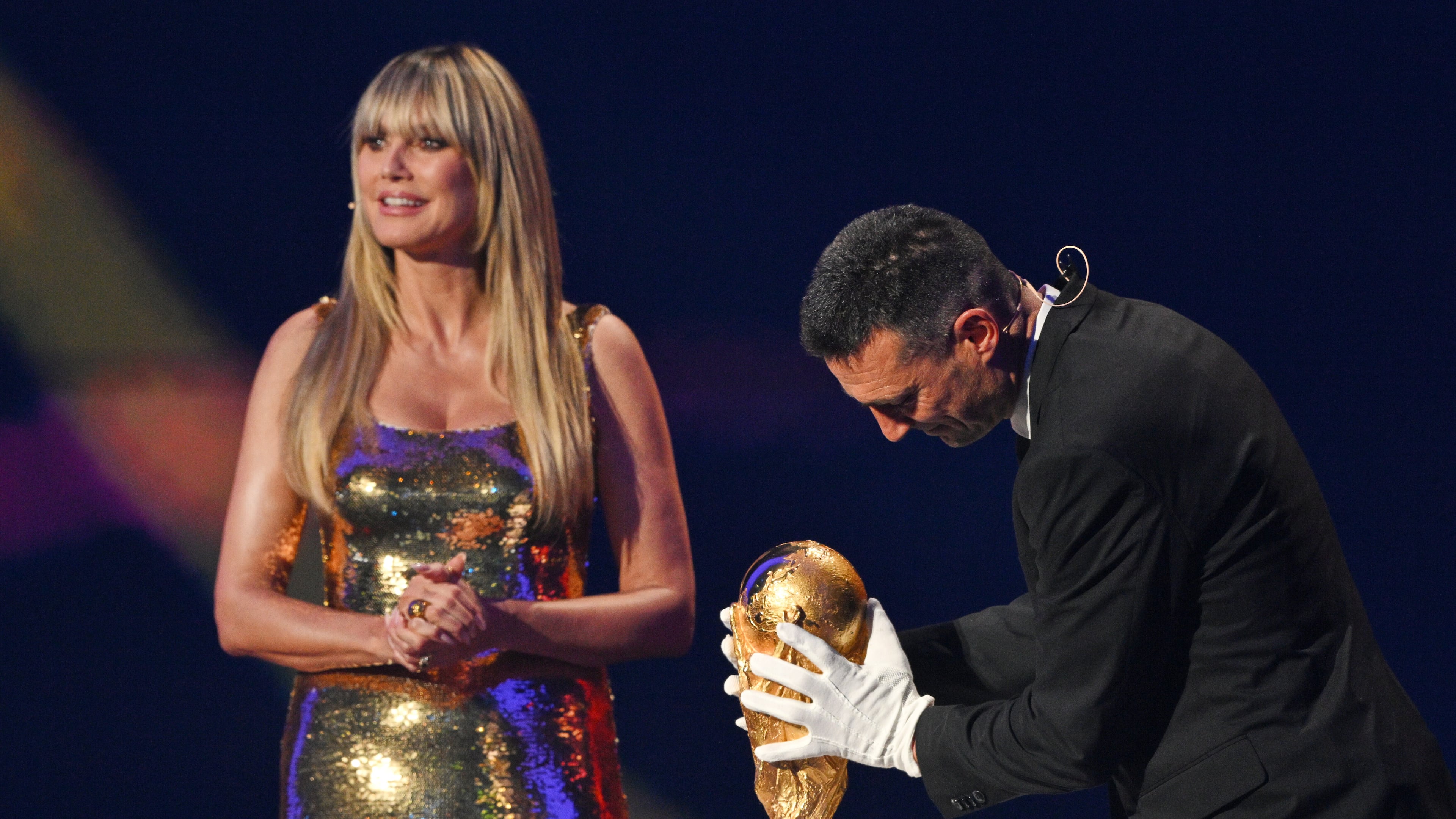Model Heidi Klum watches as Argentina's coach Lionel Scaloni returns the World Cup trophy to the stage during the draw for the 2026 soccer World Cup at the Kennedy Center in Washington, Friday, Dec. 5, 2025 (Mandel Ngan/Pool Photo via AP)