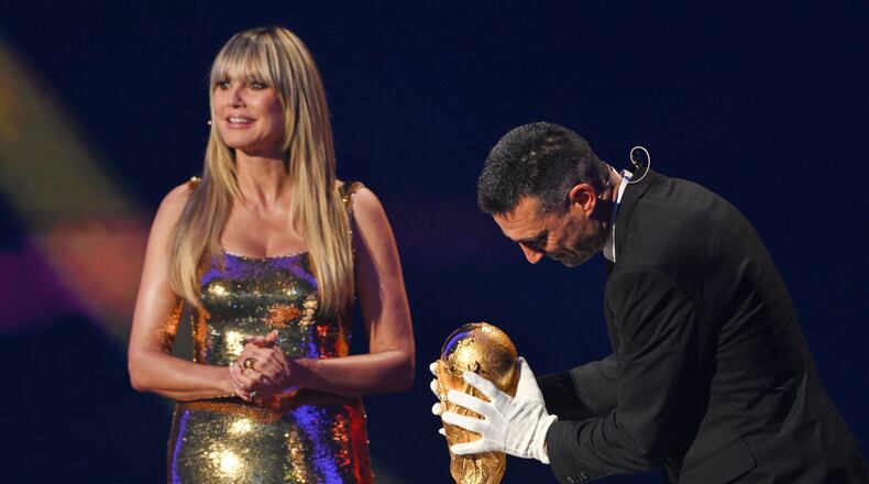 Model Heidi Klum watches as Argentina's coach Lionel Scaloni returns the World Cup trophy to the stage during the draw for the 2026 soccer World Cup at the Kennedy Center in Washington, Friday, Dec. 5, 2025 (Mandel Ngan/Pool Photo via AP)