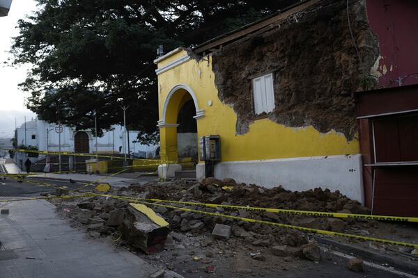 A police tape surrounds a damaged building in Palin, Guatemala, Wednesday, July 9, 2025, after a series of earthquakes with magnitudes ranging from 3.0 to 5.6, according to authorities. (AP Photo/Moises Castillo)