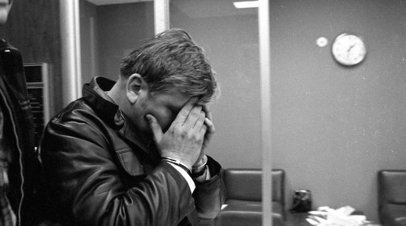 At the Des Plaines, Illinois, police station, John Wayne Gacy covers his face with his manacled hands as he emerged after an all-night questioning session on Dec. 22, 1978. A North Carolina man who moved to Chicago was one of the victims of Gacy, who was convicted of killing 33 young men and boys in the 1970s, authorities said Monday. (Roy Hall/Chicago Tribune/TNS)