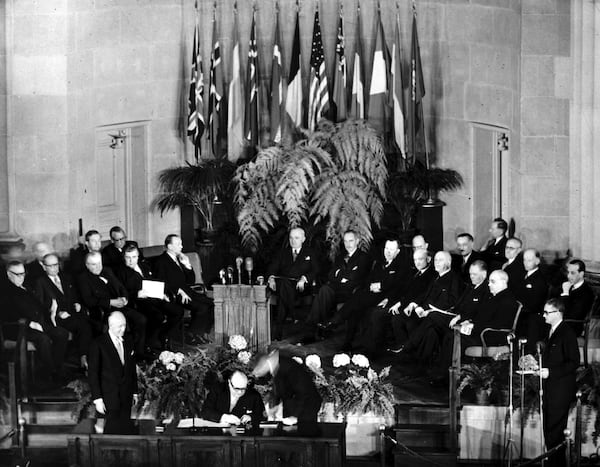 FILE - Belgium's Prime Minister Paul-Henri Spaak, seated center, signs the North Atlantic Pact in Washington, DC, April 4, 1949, flanked by Belgium's Ambassador to the U.S., Baron Silvercruys, left, and John W. Foley of the U.S. State Department. Seated behind, from left, are Britain's Ernest Bevin, Norway's Halvard Lange, Luxembourg's Joseph Bech, Iceland's Bjarni Benediktsson, Denmark's Gustav Rasmussen, U.S. President Harry S. Truman, U.S. Secretary of State Dean Acheson; Canada's Lester Pearson, France's Robert Schuman, Italy's Count Carlo Spforza, Holland's Dirk Stikker and Portugal's Jose Caeiro Da Matta. (AP Photo, File)
