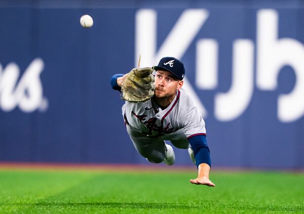 Braves outfielder Jarred Kelenic makes a diving catch in Toronto. (Thomas Skrlj / AP)