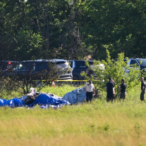 Emergency personnel investigate the site of a plane crash at the Butler Memorial Airport in Butler, Mo., Sunday, June 14, 2026. (AP Photo/Reed Hoffmann)