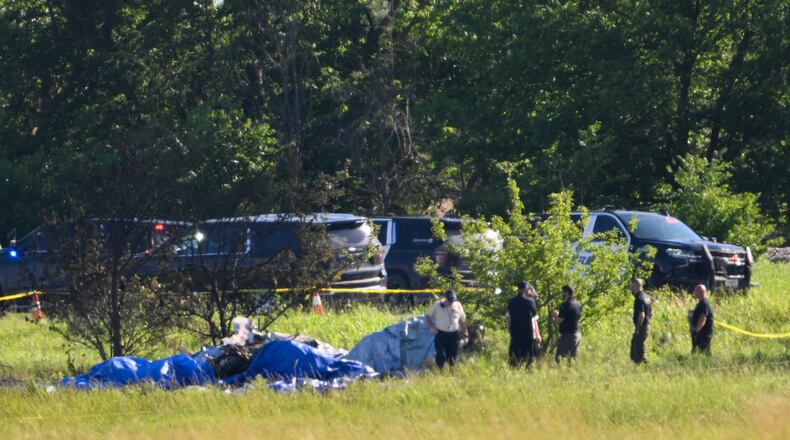 Emergency personnel investigate the site of a plane crash at the Butler Memorial Airport in Butler, Mo., Sunday, June 14, 2026. (AP Photo/Reed Hoffmann)